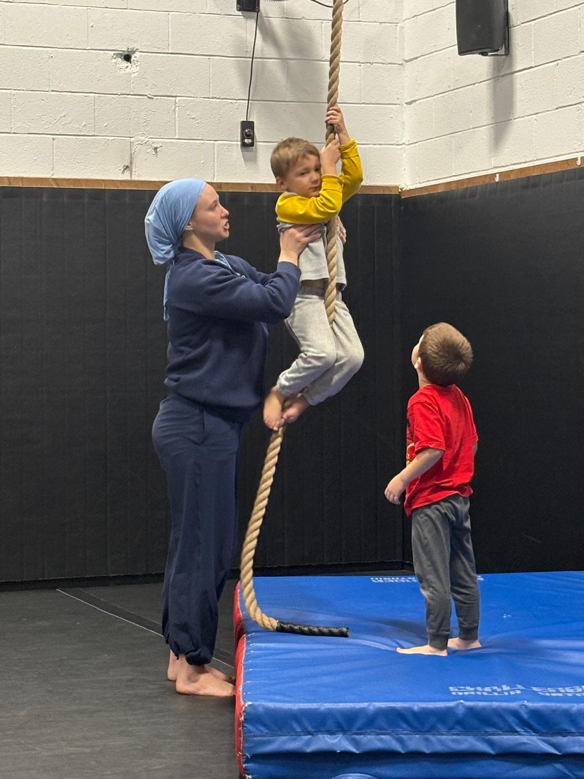 A United Grappling Club coach helping a young child with a movement exercise